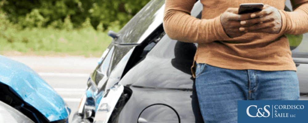 Motorist holding his phone after a car accident