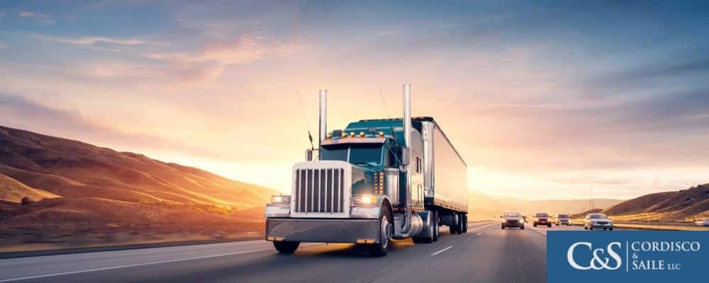 truck driving on highway with sunset in background