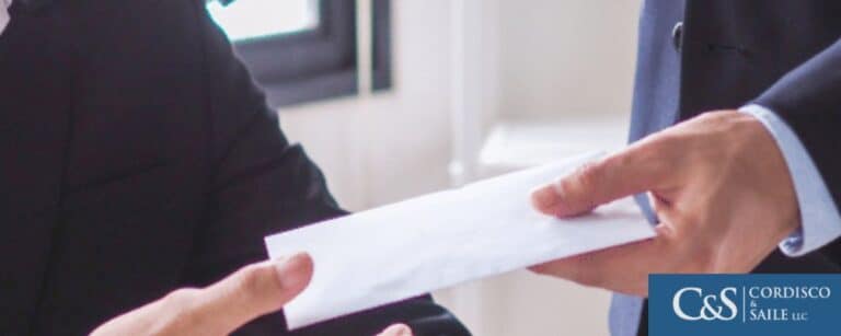 A man handing over an envelope containing a crps compensation