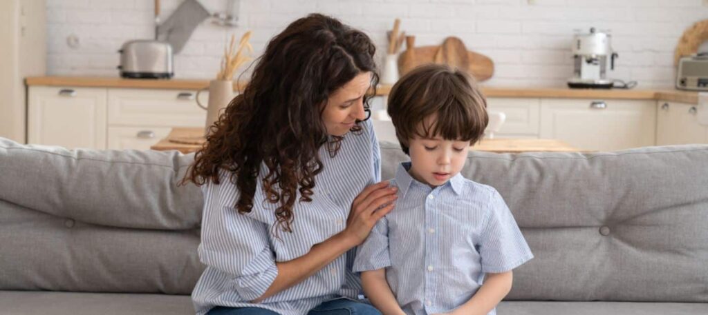 parent sitting with and talking to worried child