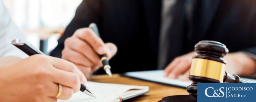 An image of an attorney speaking with one or more clients, possibly discussing a legal matter or providing counsel.