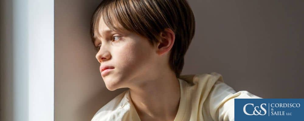 young child sadly looking out of window